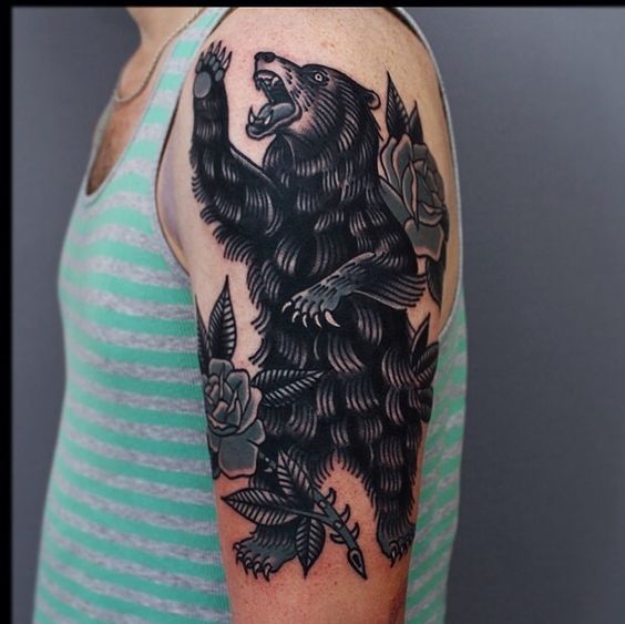 Tinta de oso de estilo tradicional en la parte superior del brazo izquierdo