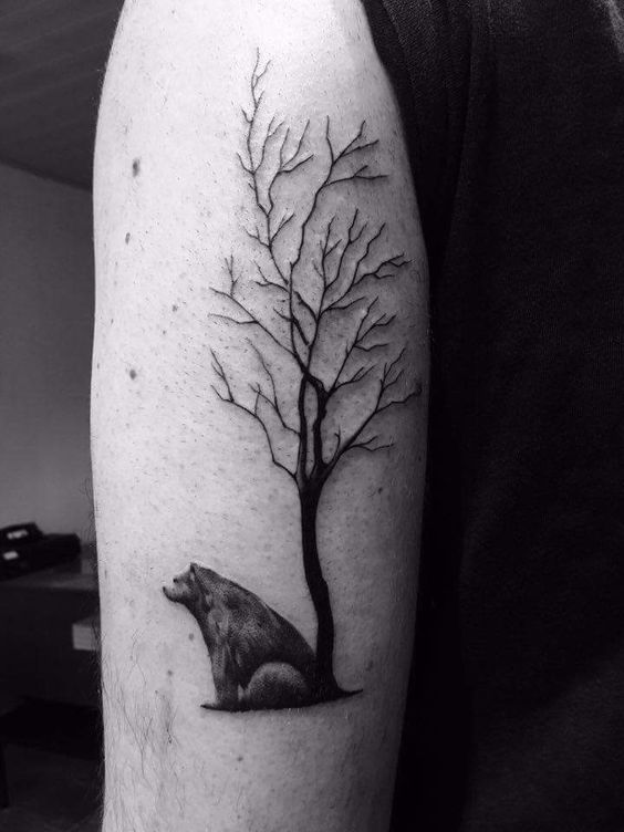 Tatuaje de oso sentado cerca del árbol en el brazo izquierdo