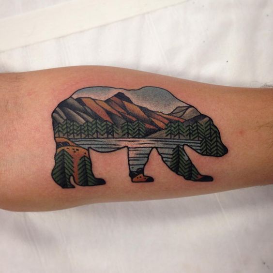 Tatuaje en el brazo, oso con paisaje natural