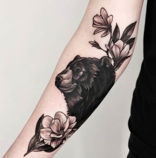 Tatuaje en el antebrazo, oso negro con flores