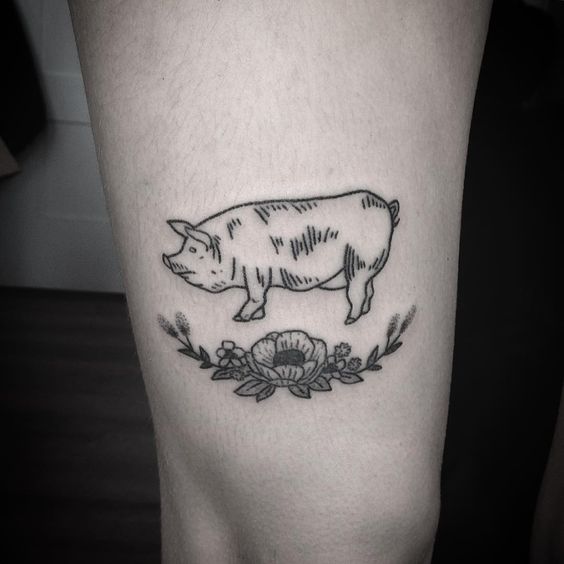 Tatuaje de cerdo y flores.