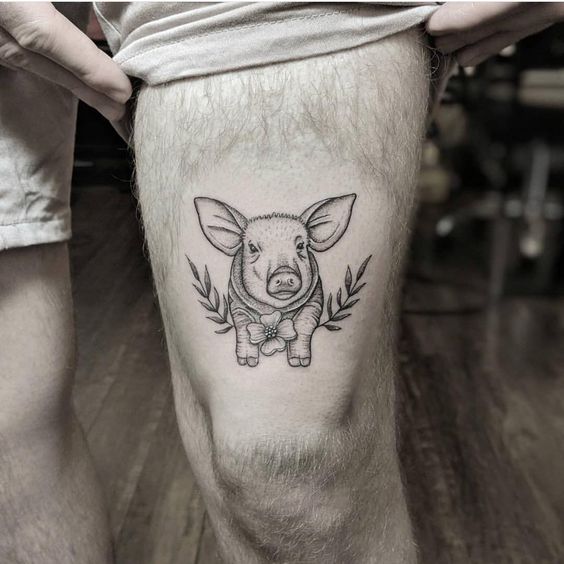 Tatuaje de cerdo en el muslo izquierdo.