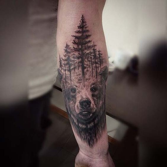 Impresionante diseño de tatuaje de un oso realista y árboles encima